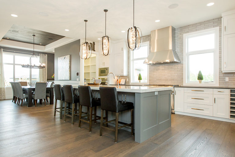 The Manor - Kitchen - Above the charcoal island are 3 black iron pendant light fixtures wrapped around a sparkling string of chrome and crystal.